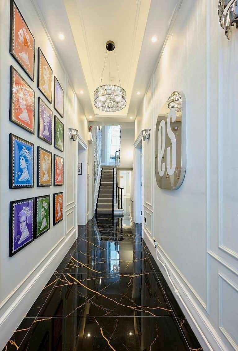 Hallway with framed pop art prints and a black marble floor at ES London
