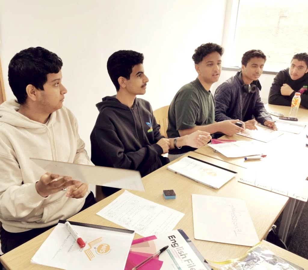 Teenage students working at a shared desk in class at Newcastle International School