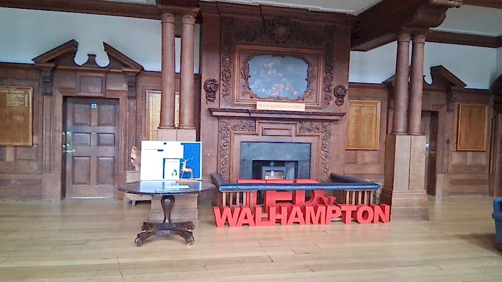 Wood-panelled entrance hall with red ILH Walhampton letters on the floor