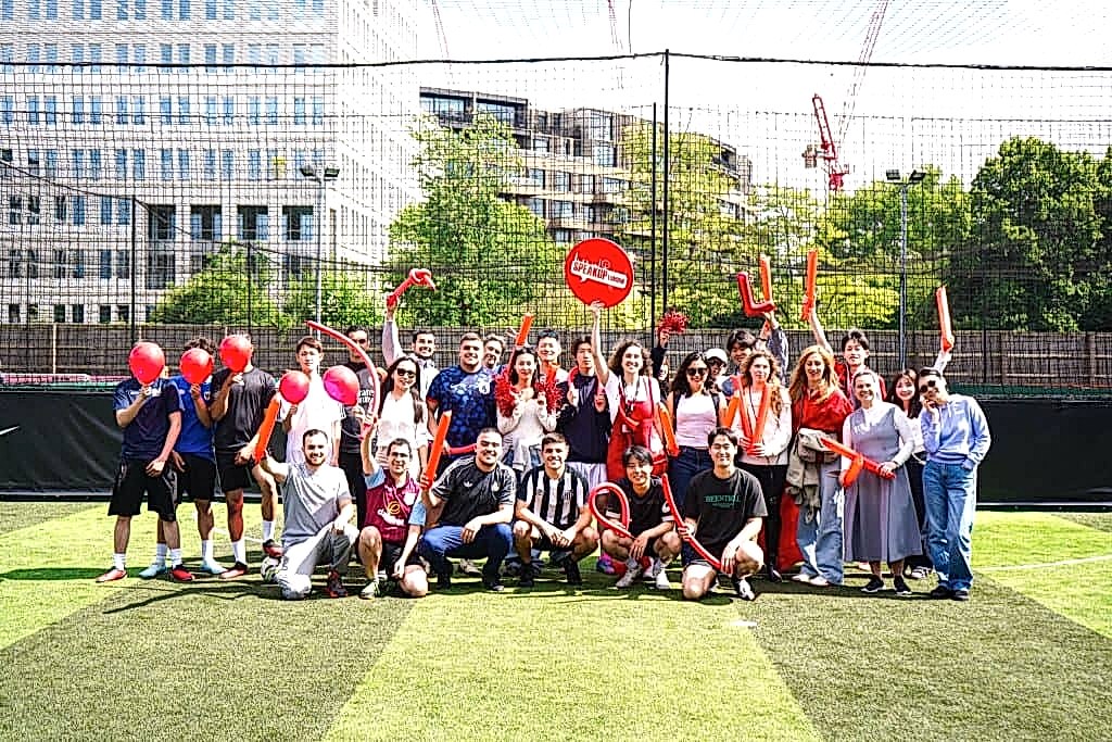 Speak Up London students posing with balloons on an outdoor football pitch
