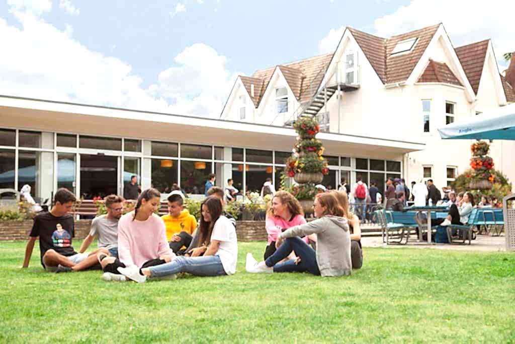 Students sitting on the grass in the gardens at Anglo-Continental Bournemouth