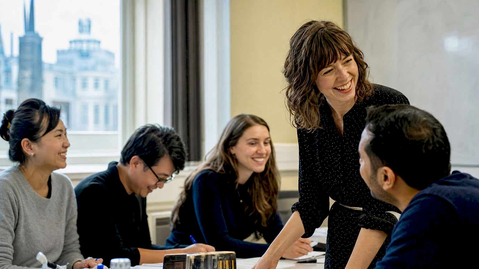 A teacher and students laughing during a General English class
